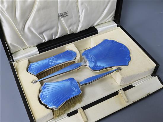 A cased George V Art Deco silver and enamel three piece dressing table set, Charles S. Green & Co, Birmingham, 1933.